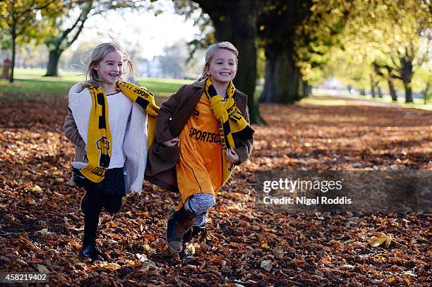 Two girls run through autumn leaves on their way to the KC Stadium ahead of the Premier League Football match between Hull City and Southampton at KC...