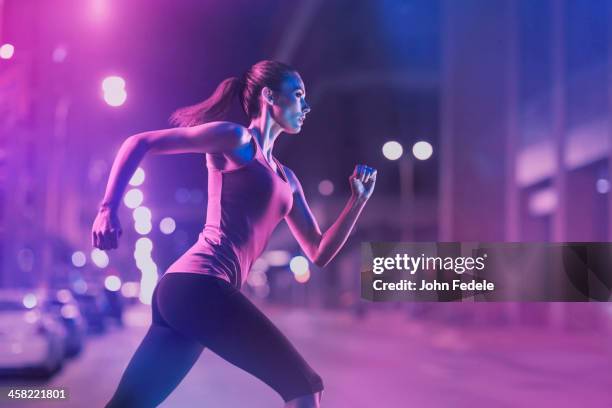 caucasian woman running on city street - running lights stock pictures, royalty-free photos & images