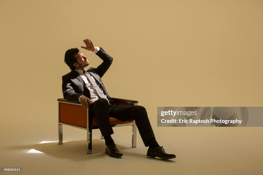 Caucasian businessman sitting under spotlight