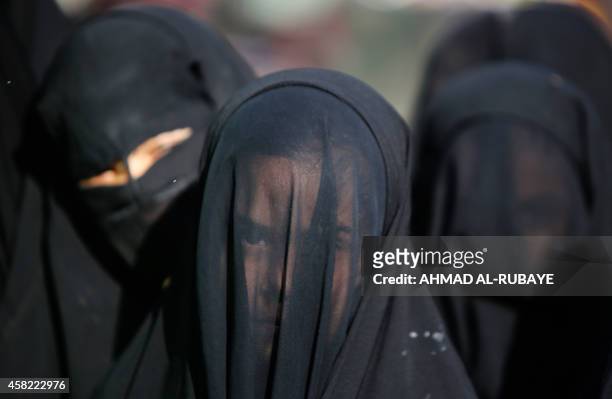 An Iraqi Shiite girl, whose face is covered with a veil, takes part in a parade in preparation for the peak of the mourning period of Ashura in...