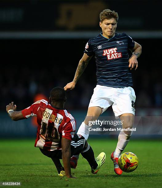 Jeff Hendrick of Derby is tackled by Moses Obubajo of Brentford during the Sky Bet Championship match between Brentford and Derby County at Griffin...