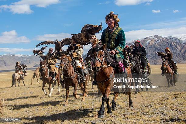 mongolian eagle hunters riding to the festival. - semi arid stock pictures, royalty-free photos & images