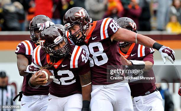 Running back Marshawn Williams of the Virginia Tech Hokies celebrates his touchdown run with teammate tight end Ryan Malleck against the Boston...