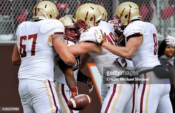 Running back Myles Willis of the Boston College Eagles is surrounded by teammates as he celebrates his touchdown run against the Virginia Tech Hokies...