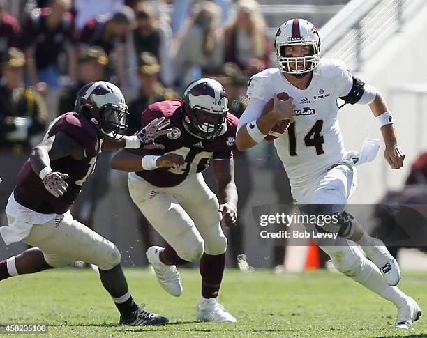 Pete Thomas of the Louisiana Monroe Warhawks rushes past Jarrett Johnson of the Texas A&M Aggies at Kyle Field on November 1, 2014 in College...