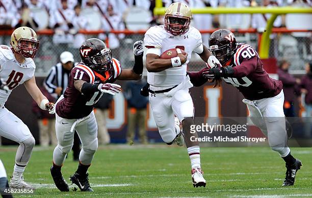 Quarterback Tyler Murphy of the Boston College Eagles rushes past cornerback Kendall Fuller of the Virginia Tech Hokies and defensive end Dadi...