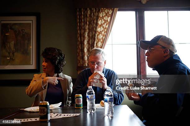 Elaine Chao sits next to her husband Senate Minority Leader Mitch McConnell as he eats a hot dog during a campaign rally and hot dog roast at the Old...