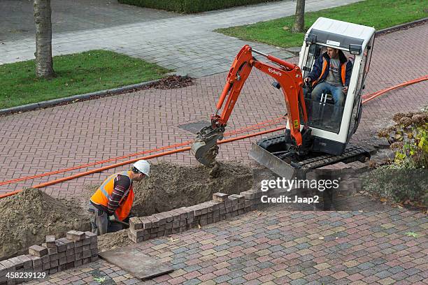 preparing dutch homes for using fiber optics (ftth) - grondverzetmachine stockfoto's en -beelden
