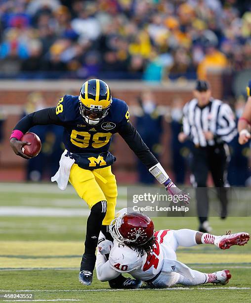 Devin Gardner of the Michigan Wolverines runs for a short gain as Antonio Allen of the Indiana Hoosiers makes the stop during the third quarter of...