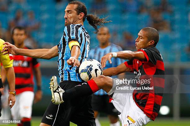 Hernan Barcos of Gremio battles for the ball against Nino of Vitoria during the match Gremio v Vitoria as part of Brasileirao Series A 2014, at Arena...
