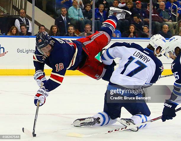 Marc Staal of the New York Rangers gets the second period shot off as he is flipped by Adam Lowry of the Winnipeg Jets at Madison Square Garden on...