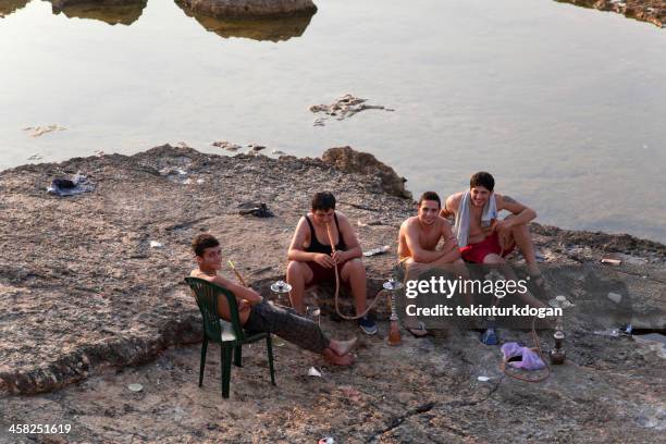 young teenagers are smoking hookah at beach of beirut lebanon - beiroet beach stockfoto's en -beelden