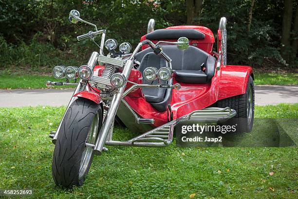 フロントビューの赤色自動三輪車に駐車中の芝生 - 三輪車 ストックフォトと画像