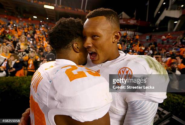 Teammates Cameron Sutton and Joshua Dobbs of the Tennessee Volunteers celebrate after defeating the South Carolina Gamecocks 45-42 in overtime at...