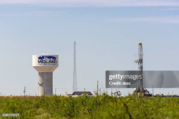 pozo de petróleo torre perforadora y torre de agua en midland en texas - midland fotografías e imágenes de stock