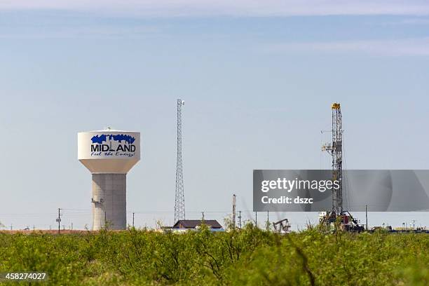 oil well drilling rig and water tower in midland texas - midland texas stockfoto's en -beelden