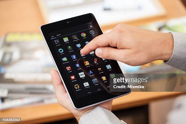 man holding google nexus 7 digital tablet - asustek stock pictures, royalty-free photos & images