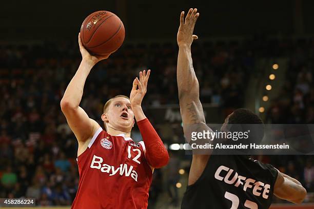 Robin Benzing of Muenchen is challenged by Michael Cuffee of Tuebingen during the Beko Basketball Bundesliga match between FC Bayern Muenchen and...