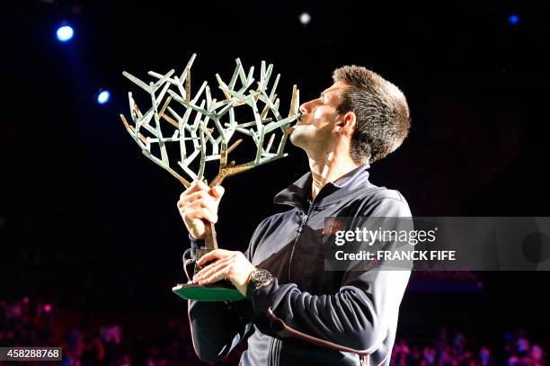 Serbia's Novak Djokovic poses with the trophy after winning the final match against Canada's Milos Raonic at the ATP World Tour Masters 1000 indoor...