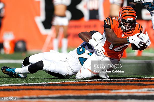 Mohamed Sanu of the Cincinnati Bengals dives into the end zone past J.T. Thomas of the Jacksonville Jaguars to score a touchdown during the second...
