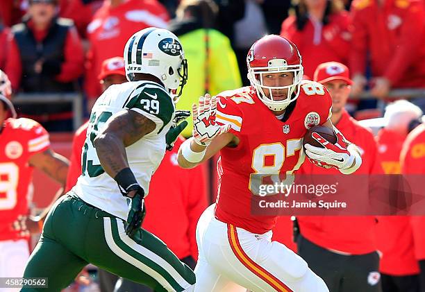 Travis Kelce of the Kansas City Chiefs runs the ball against Antonio Allen of the New York Jets during the first half at Arrowhead Stadium on...