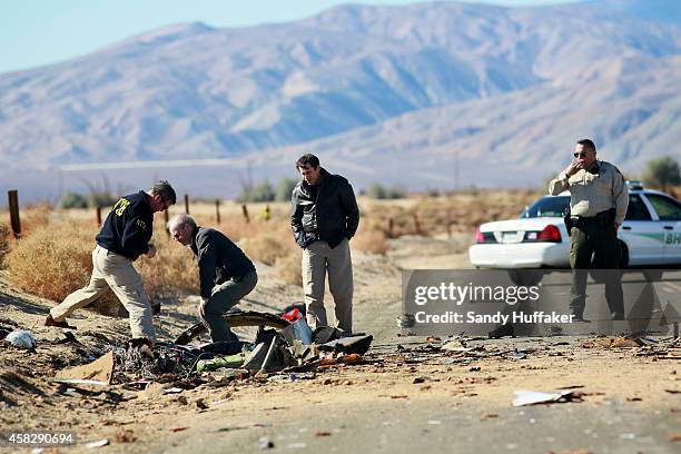 Agents from the National Transportation Safety Board , FBI and Sheriff's comb through the wreckage of the Virgin Galactic SpaceShip 2 in a desert...