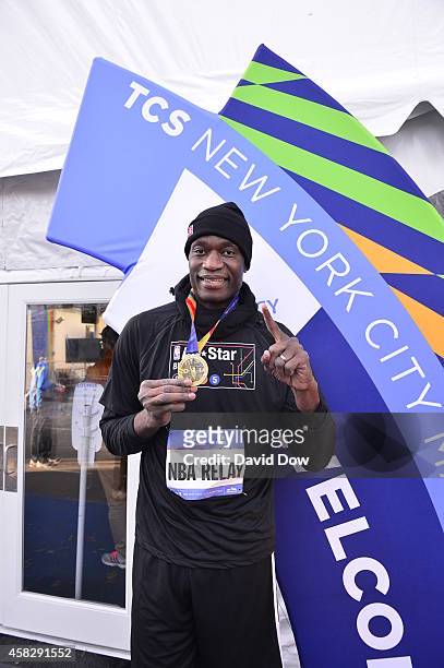 Former NBA player Dikembe Mutombo poses with his medal after he finishes the last leg of the race during the 2014 NBA All-Star Relay at the TSC New...