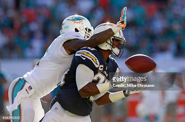 Wide receiver Mike Wallace of the Miami Dolphins knocks a potential interception away from defender Darrell Stuckey of the San Diego Chargers in the...