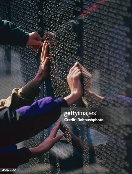 close-up de mãos na parede memorial de guerra do vietname - vietnam veterans memorial imagens e fotografias de stock