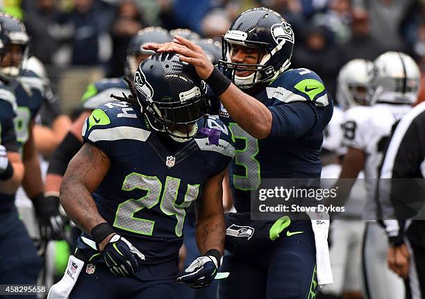 Quarterback Russell Wilson of the Seattle Seahawks celebrates with running back Marshawn Lynch of the Seattle Seahawks after Lynch scored a touchdown...