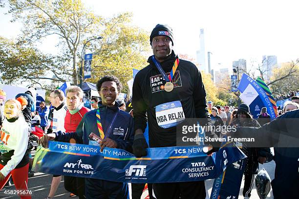 Former NBA player Dikembe Mutombo poses for a photo with Jontai Williams after they finish the last leg of the TCS New York City Marathon as part of...