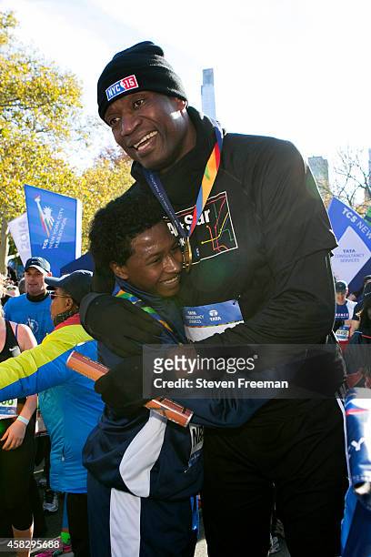 Former NBA player Dikembe Mutombo celebrates with Jontai Williams after they finish the last leg of the TCS New York City Marathon as part of the NBA...