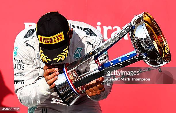 Lewis Hamilton of Great Britain and Mercedes GP kisses the trophy as he celebrates on the podium following his victory in the United States Formula...