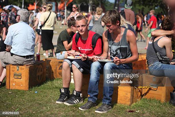 people eating and resting during roskilde music-festival in denmark - musikfestival stock pictures, royalty-free photos & images