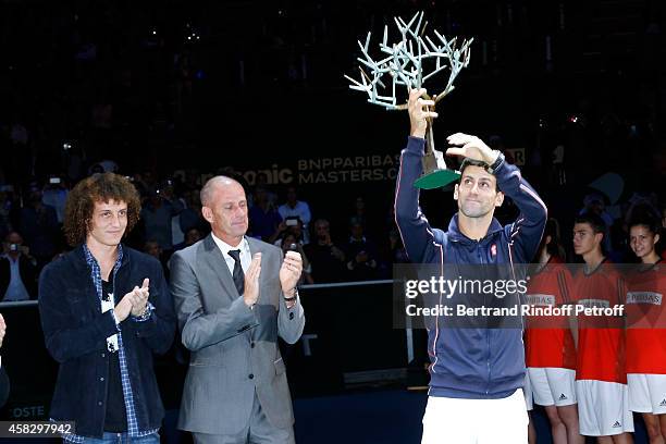 Football player David Luiz, Director of the BNP Paribas Masters Guy Forget and winner of the tournament Novak Djokovic attend the Final match during...