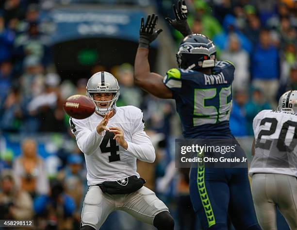 Quarterback Derek Carr of the Oakland Raiders passes against defensive end Cliff Avril of the Seattle Seahawks at CenturyLink Field on November 2,...