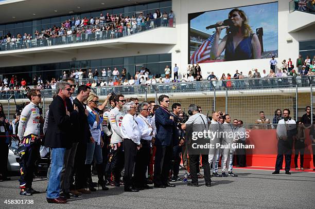 Supremo Bernie Ecclestone, former champion Mario Andretti, actors Keanu Reeves and Pamela Anderson and the drivers stand for the national anthem...