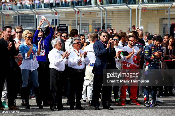 Supremo Bernie Ecclestone, former champion Mario Andretti, actors Keanu Reeves and Pamela Anderson and the drivers stand for the national anthem...