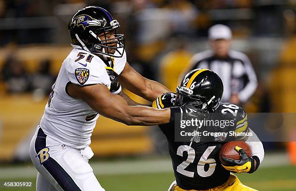 Le'Veon Bell of the Pittsburgh Steelers tries to break a tackle by Daryl Smith of the Baltimore Ravens during the first quarter at Heinz Field on...