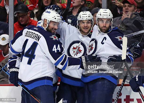 Michael Frolik of the Winnipeg Jets celebrates his first period goal with Zach Bogosian and Andrew Ladd against the Chicago Blackhawks at the United...