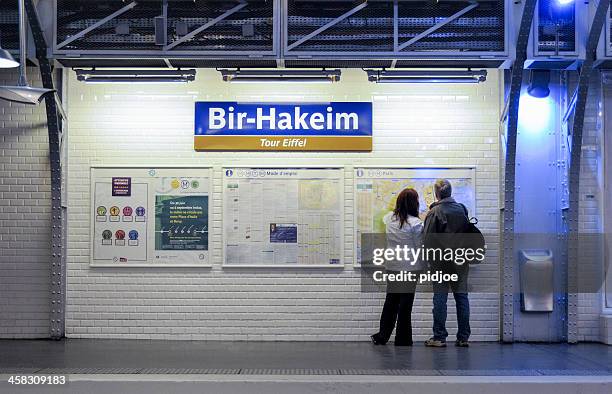 man and woman looking at map in paris metro station - paris metro stock pictures, royalty-free photos & images
