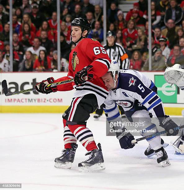 Mark Stuart of the Winnipeg Jets slips and collides with Andrew Shaw of the Chicago Blackhawks at the United Center on November 2, 2014 in Chicago,...