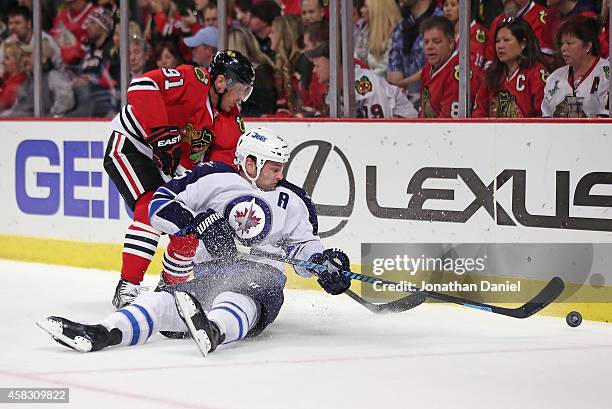 Mark Stuart of the Winnipeg Jets knocks the puck away from Brad Richards of the Chicago Blackhawks at the United Center on November 2, 2014 in...