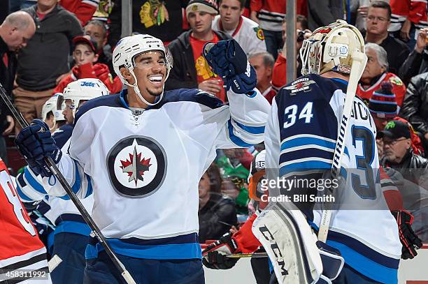 Evander Kane of the Winnipeg Jets celebrates with goalie Michael Hutchinson after defeating the Chicago Blackhawks 1-0 during the NHL game on...