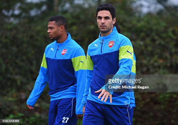 Serge Gnabry and Mikel Arteta look on during an Arsenal training session ahead of the UEFA Champions League match against RSC Anderlecht at London...