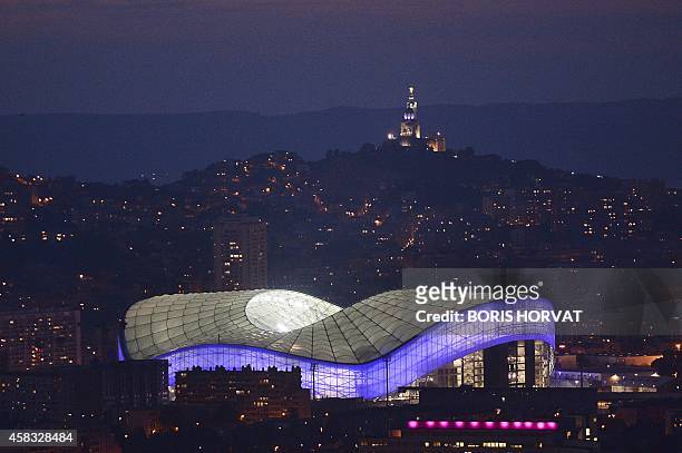 Picture taken on November 2, 2014 shows the illuminated new Velodrome Stadium at sunset in Marseille, southern France. The Stade Velodrome, which...