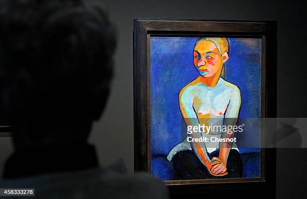 Visitor looks at a painting 'Jeune finlandaise' by French artist Sonia Delaunay during the press day at Museum of Modern Art on November 3, 2014 in...