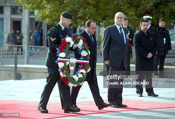 French President Francois Hollande, places a wreath with Veterans of war secretary Julian Fantino at the National War Memorial November 3, 2014 in...