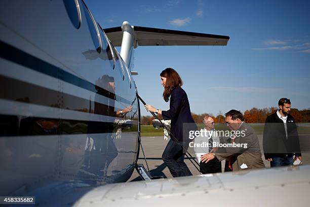 Alison Lundergan Grimes, Democratic candidate for the U.S. Senate, left, boards a charter plane after delivering remarks during a campaign stop at...