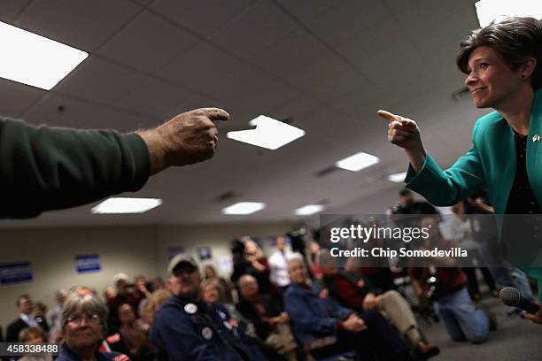 Republican U.S. Senate candidate Joni Ernst trades compliments with a supporter while addressing a crowd at the Johnson County GOP Victory Office...